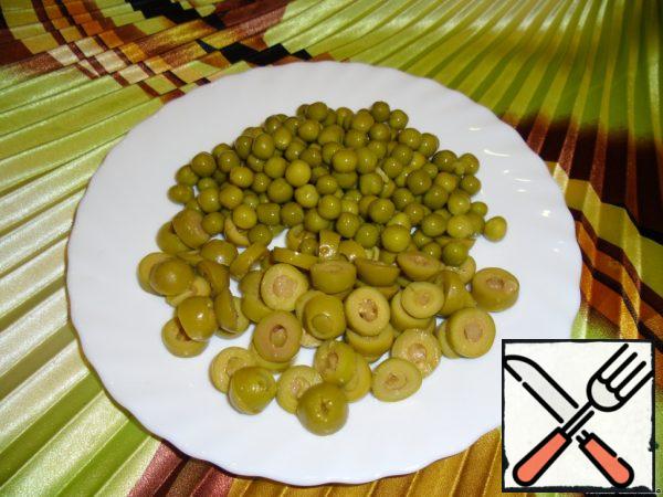Cut the olives into 3 parts. Spread the peas.