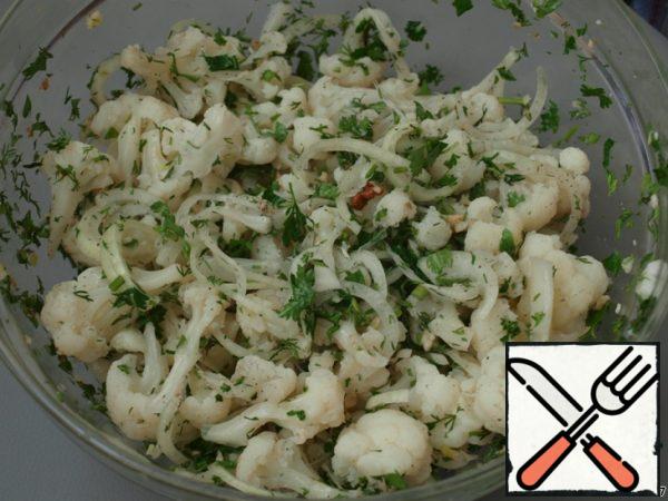 Cool the cabbage, disassemble it into stalks or cut into small pieces. Cut the onion into half rings, finely chop the greens. Stir, add the chopped walnuts and squeeze out the garlic.