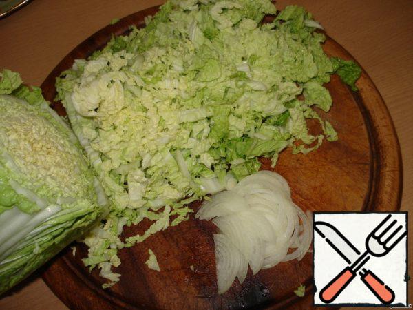 Slice the Peking cabbage and cut the onion into half rings.