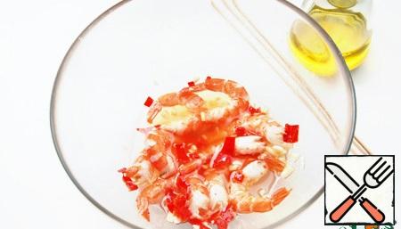 For the marinade, mix the finely chopped chili pepper (without seeds), garlic and olive oil. Defrost, peel and marinate the prawns for at least 30 minutes.