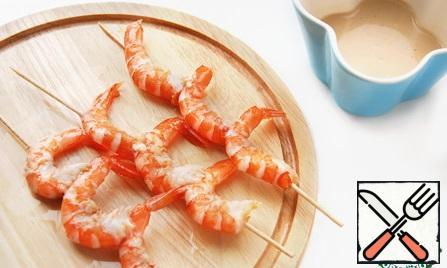 Shrimps strung on wooden skewers for 3 pieces and fry without oil for 1-2 minutes.
Put the salad on a platter, pour balsamic sauce and garnish with skewers with prawns. For stability, stick skewers in the tangerine slices.