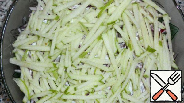 The next layer is an apple, cut into thin strips, and mayonnaise.