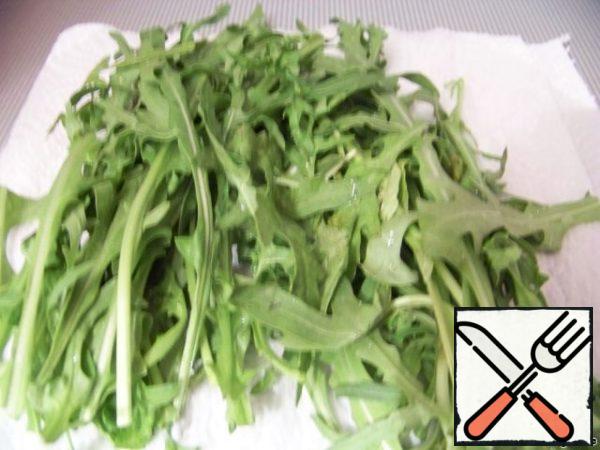 Rinse the arugula leaves with water and dry them on a paper towel.