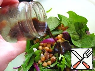 In a large bowl, combine the spinach (if the leaves are too large, tear them), chickpeas and onions. Add the dressing, first removing the garlic from it. Stir.