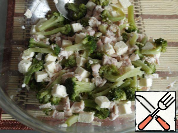 Divide the broccoli into florets, add the sliced chicken and cheese. Stir.