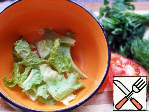 Tear the lettuce leaves by hand and put them in a salad bowl.