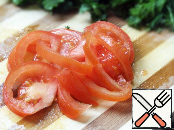 Cut the tomato in half, then cut it into thin slices.
