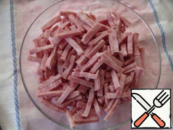 First of all, put the eggs to boil. Hard-boiled.
Now cut the ham into strips.