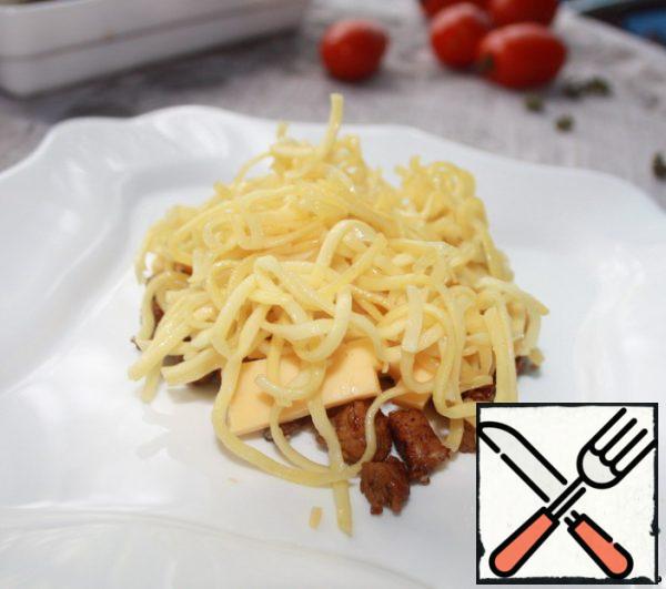 Put the meat on a plate, top with sausage, cheese, and noodles.