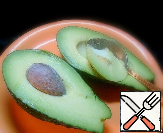Cut the avocado lengthwise. With a spoon, we take out the flesh and cut it randomly.