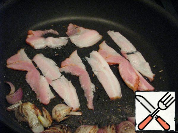 The next step is to spread the bacon.
The onion can be removed from the pan, but I, like the author, just moved it to the very edge.
Bacon (in the original pancetta, but nowadays you can't find it in the daytime with fire). Deep-fried until crisp.