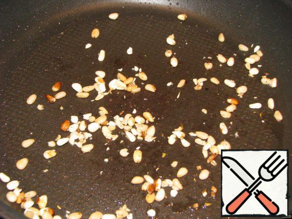 Quickly fry the pine nuts.