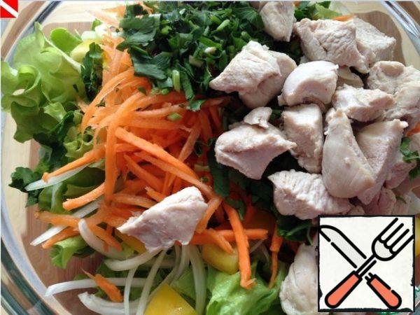 Everything is ready - we proceed to the mise en scene, that is, we begin to assemble the salad. Squeeze out the carrots, cut (not finely) the breast and parsley. Don't forget about funchose. Season with sauce.