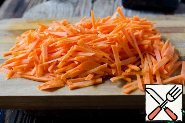 Peel the carrots and cut them into strips.
