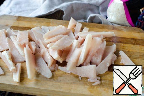 Cut the chicken breast into thin strips.