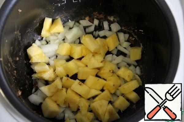In the slow cooker, put the finely chopped onion and pineapple, cut into slices and cook for 15 minutes, stirring occasionally.