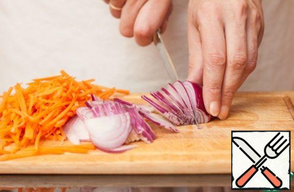 Cut the carrots into cubes using the same grater, cut the onion thinly along the plates, and chop the garlic.
