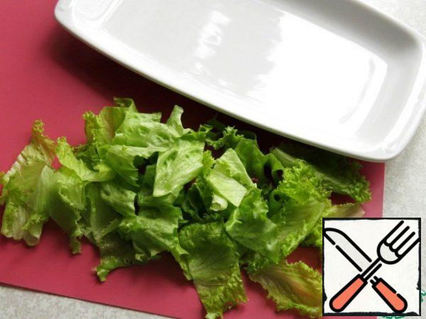 Then wash the lettuce leaves, let the water drain, tear or cut at random and put on a dish.