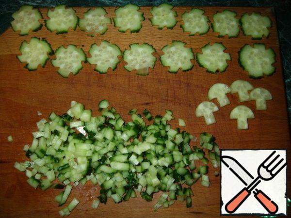 Part of the cucumber cut and prepare for decoration, then the rest of the trim and trim from the decoration finely cut. Add to the tuna and onion.