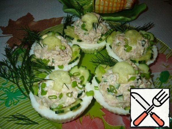 Add mayonnaise. Stir. Fill egg tartlets with the resulting salad and garnish with prepared cucumbers and herbs if desired.