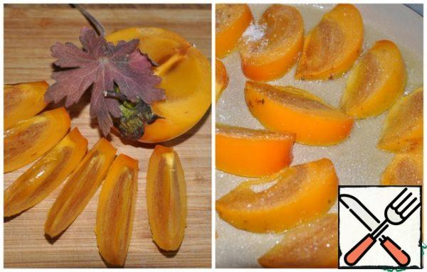 Wash the persimmon and remove the stems, then cut it into 12 slices. Heat a frying pan, add butter, put slices of persimmon on it and sprinkle sugar on top. Fry the slices on both sides over high heat so that caramel forms on the surface. You need to turn the slices very carefully so that they remain whole. Place the caramelized slices of persimmon on top of the cabbage.