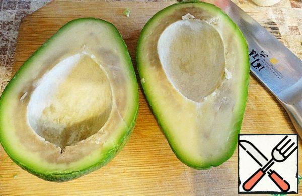 Cut the avocado in half lengthwise and remove the stone. carefully. to avoid damaging the skin, pull out the flesh.