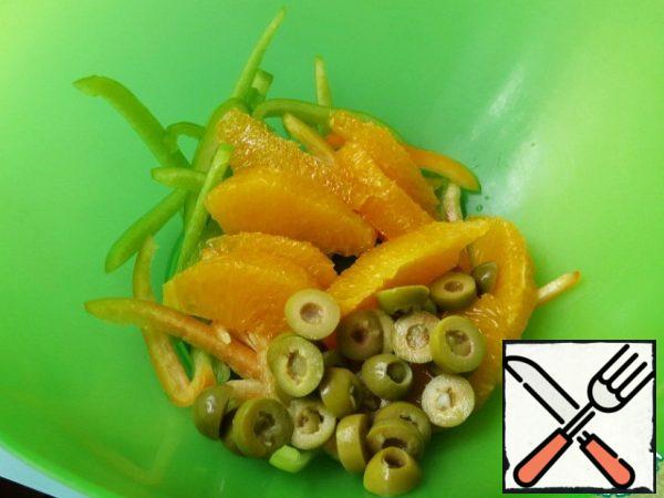 Orange cut into slices without partitions and films, olives rings.