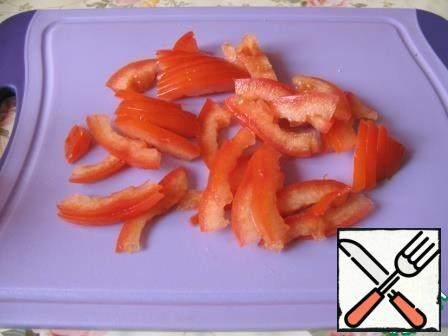 Remove the seeds from the tomato and cut the flesh into strips.