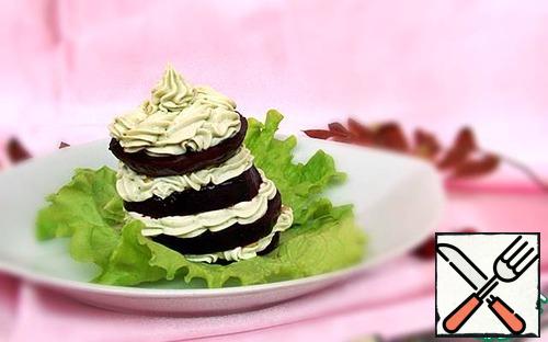 On the lettuce leaves, we begin to lay out our pyramid with a beet ring. We will put our cream on it beautifully and cover it with the next ring. We finish our pyramid with a layer of cream, beautifully deposited on beets:
