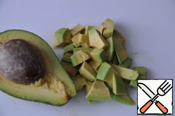 Peel the avocado and cut it into cubes.