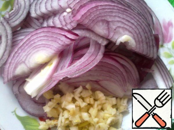 Chopped garlic. Cut the onion into thin half-rings.