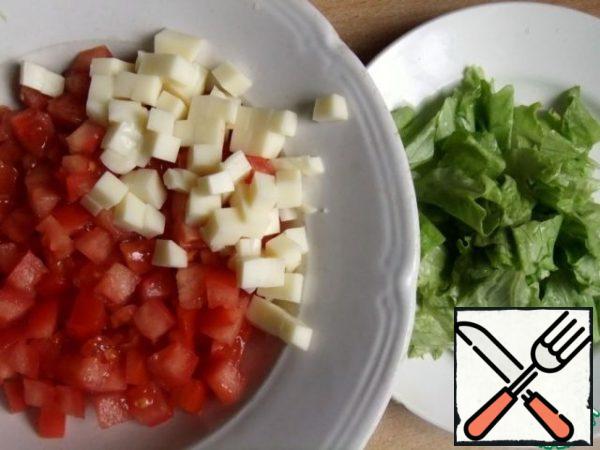 Cut the tomatoes and cheese into cubes. Wash and dry the salad. Tear it to pieces with your hands.