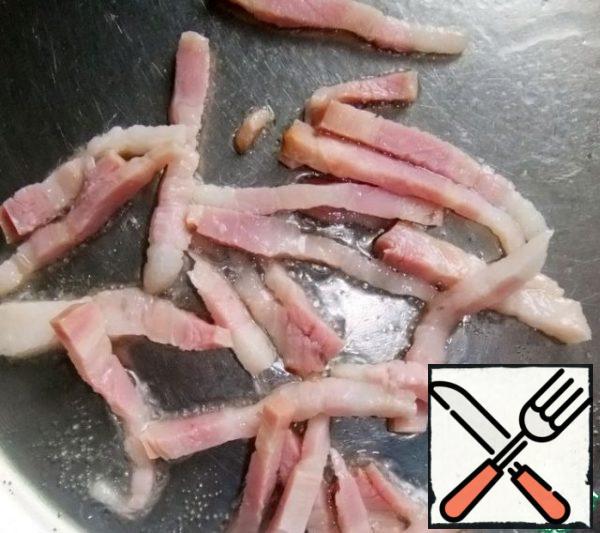 Cut the bacon into small pieces and fry it in a pan.