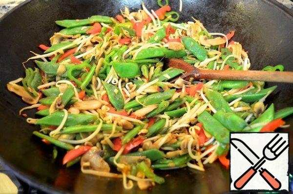 Pour the dressing over everything, mix and warm up for 2 minutes. Sprinkle with green onions. Serve with noodles.