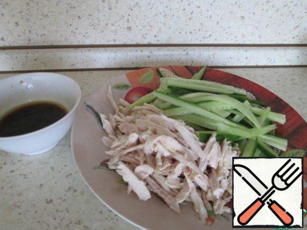 Cut the cucumbers lengthwise into long thin strips. Disassemble the chicken meat into fibers.