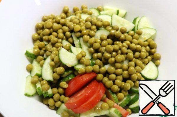 In a large salad bowl, mix cucumbers, tomatoes and green peas.