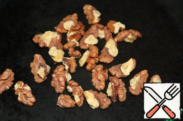 Fry the walnuts in a frying pan. Slice a little and sprinkle them over the salad.