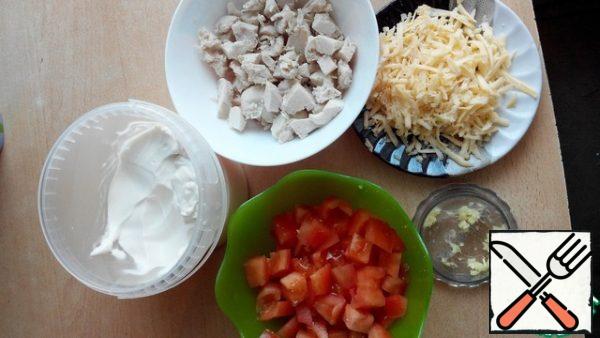 Boil the breast, cool and cut, grate the cheese on a large grater, cut the tomato into cubes, chop the garlic.