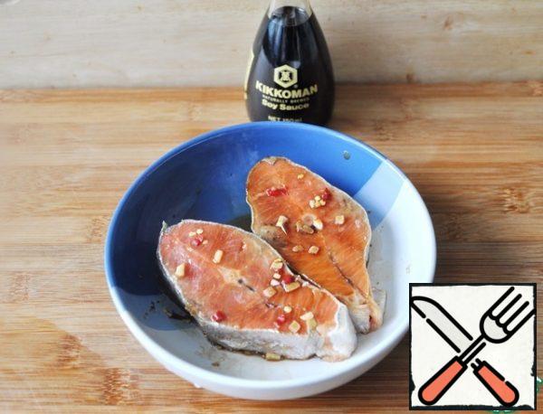 Dip the salmon steaks in the marinade and put them to marinate in a cold place for 20 minutes.