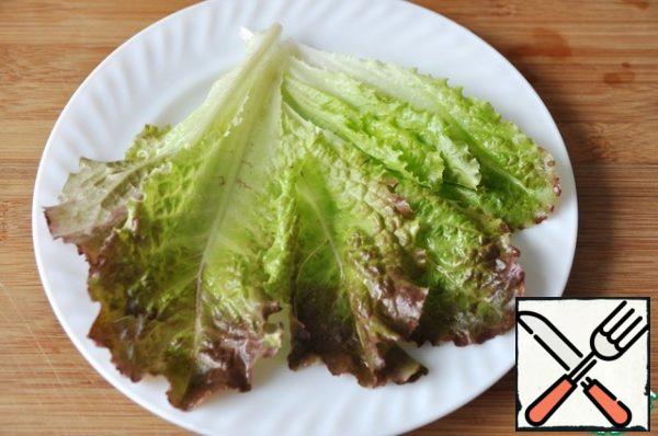 Wash the lettuce leaves, dry them and put them on a serving dish.