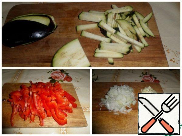 Cut the vegetables: eggplant and bell pepper strips, onion and garlic into small cubes.