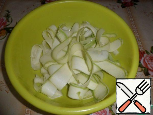 Cut the zucchini into thin slices using a vegetable peeler.