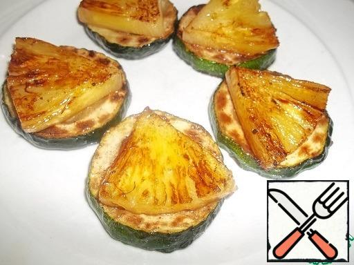 Prepare the snackr. Put pineapple slices on the fried zucchini slices.