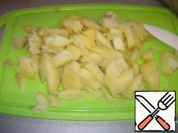 Cut the potatoes boiled in the uniform into cubes.