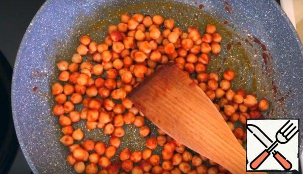 Fry the tomato puree and harissa in a pan with a spoonful of sunflower oil, add the chickpeas, and warm them up. 