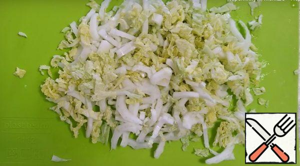 Cut the Peking cabbage across in small chunks and add it to the onion in the pan.