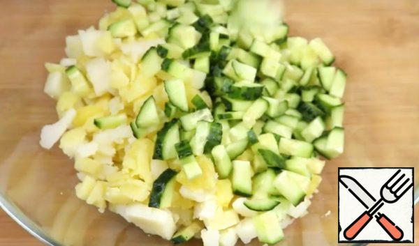Cut the potatoes and cucumber into cubes.