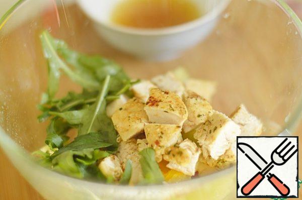Cut the finished chicken into cubes. In a bowl, mix fruit, arugula and chicken. For dressing, mix lemon and orange juices, add butter, soy sauce and honey. Mix well.