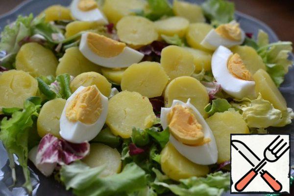 Place the lettuce leaves, potato rings and egg quarters on a serving platter.
