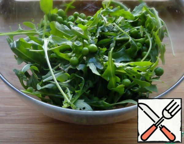 For dressing, mix lemon juice, olive oil and balsamic vinegar. Mix arugula with green peas. If you are going to use frozen peas, you need to boil them for a couple of minutes in boiling water, then flip them into a colander and pour cold water over them to stop the cooking process and preserve the green color.